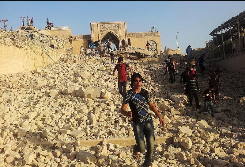 July 24, 2014: Iraqis walking in the rubble of the revered Muslim shrine after it was was destroyed by ISIL militants who overran the city in June. AP Photo
