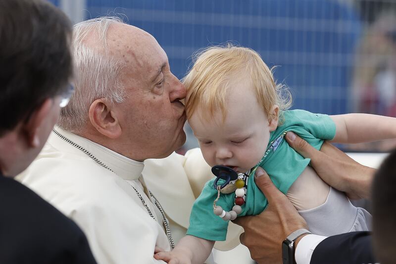 Pope Francis kisses a baby as he tours the Plains of Abraham in Quebec. Getty Images / AFP
