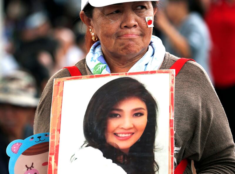 epaselect epa06161373 A supporter holds a photograph of former prime minister Yingluck Shinawatra after she failed to appear to hear her verdict at the Supreme Court's Criminal Division for Persons Holding Political Positions in Bangkok, Thailand, 25 August 2017. The Thai court issued an arrest warrant for Yingluck after she failed to appear in court for her verdict and set the new verdict date for 27 September 2017 in which she stands accused on charges of criminal negligence to stop corruption in her government's controversial rice-pledging scheme. Yingluck, who was overthrown in a 2014 military coup, will face up to 10 years in prison if the court finds her guilty.  EPA/RUNGROJ YONGRIT