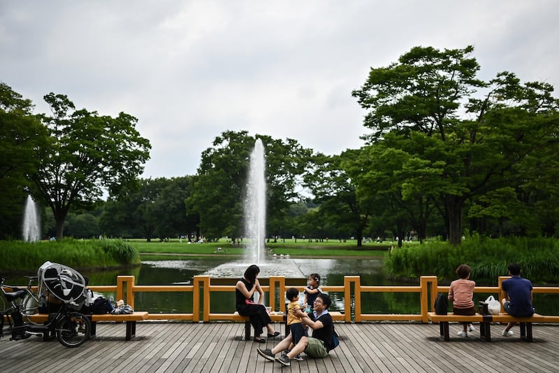 A woman and a child interact at Yoyogi Park in Tokyo on July 24, 2020. (Photo by Charly TRIBALLEAU / AFP)