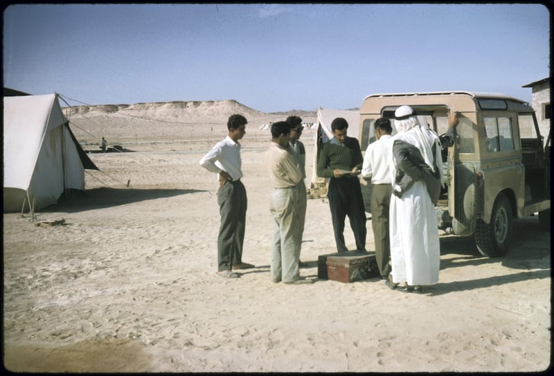 Jebel Dhana, Abu Dhabi 1963 
Employees of one of the construction sites in Jebel Dhana buying bank drafts from the British Bank of the Middle East (BBME) mobile bank landrover to send money home to their families in India, Pakistan and many of the Middle East countries.
 
The British Bank of the Middle East (BBME), Abu Dhabi town branch, offered a fortnightly banking service to all employees of various oil camps and construction sites based in and around Tarif & Jebel Dhana, as well as to Das Island, where offshore oil exploration was based. Photo by David Riley