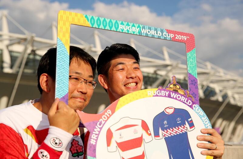 Japan fans pose for a photo outside the stadium. Getty Images