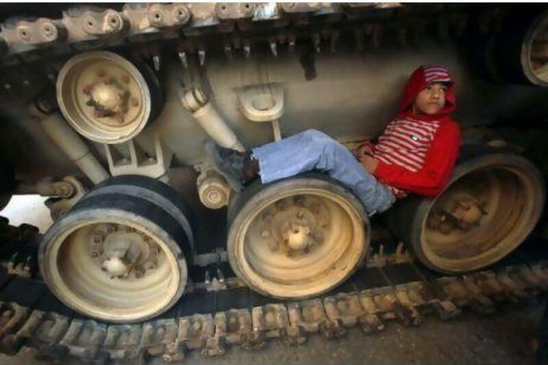 Advocacy groups are concerned that, after the political upheaval and violence in Eygpt, the physical and emotional scars on children could have devastating effects. Above, a boy sits on the tracks of a tank in Cairo.