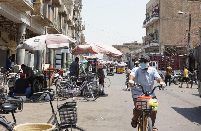 A man wearing a face mask rides a bicycle along the Al-Sadriya Market in the Iraqi capital Baghdad. AFP