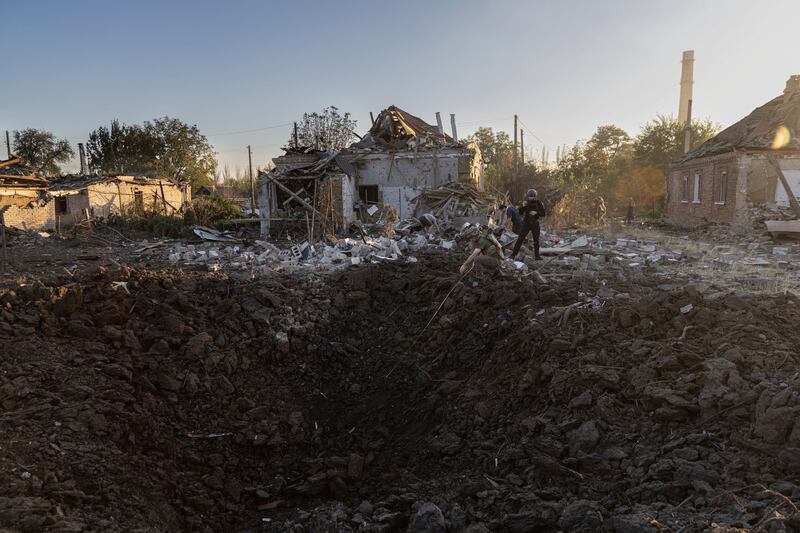 Ukrainian police look at a crater from a Russian rocket in a residential neighbourhood of Kostiantynivka, in Donetsk. AP