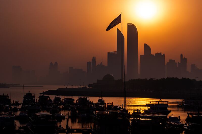 The sun rises on a hazy morning along the Corniche, Abu Dhabi. Victor Besa / The National