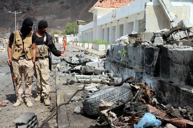 epa06563819 Yemeni soldiers inspect the site of car bomb attacks outside the headquarters of a counter-terrorism unit in the southern port city of Aden, Yemen, 25 February 2018. According to reports, at least 14 Yemenis were killed and 40 others wounded when two car suicide bombers struck the entrance of the headquarters of a counter-terrorism unit in Aden.  EPA/STRINGER