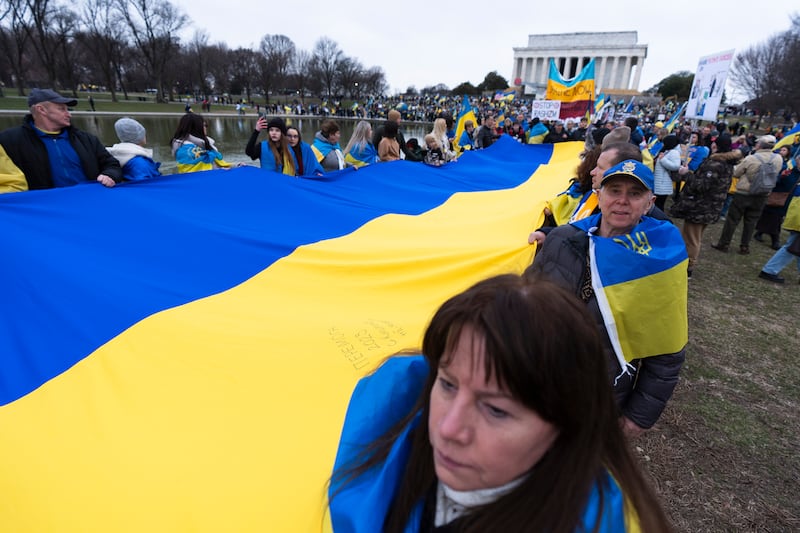 Ukrainians and their supporters carry a huge Ukrainian flag during a rally at the National Mall near the Lincoln Memorial in Washington. AP