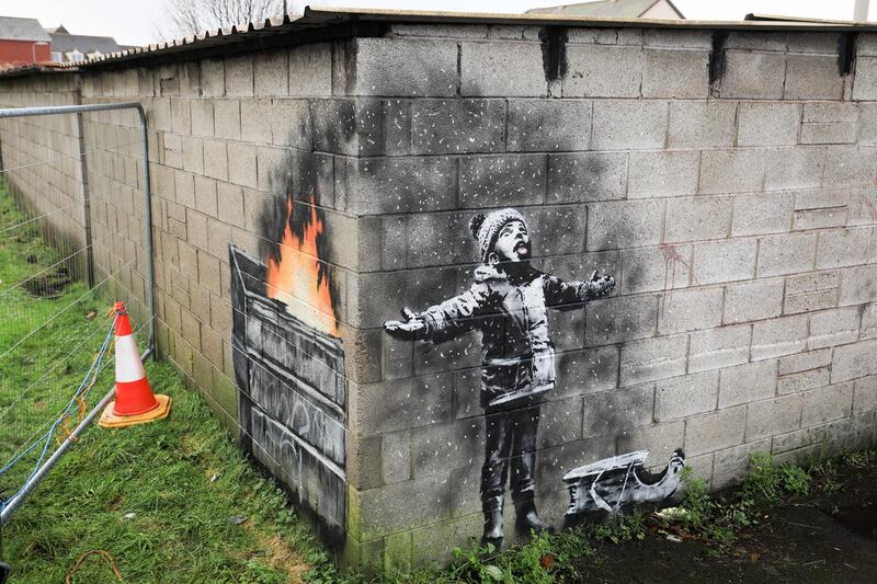 PORT TALBOT, WALES - DECEMBER 20: People gather around fences that have been erected to protect the latest  piece of artwork by the underground guerrilla artist Banksy on December 20, 2018 in Port Talbot, Wales. The British graffiti artist who keeps his identity a secret, confirmed yesterday that the artwork was his using his verified Instagram account to announce "Season's greetings" with a video of the artwork in Port Talbot. (Photo by Matt Cardy/Getty Images)