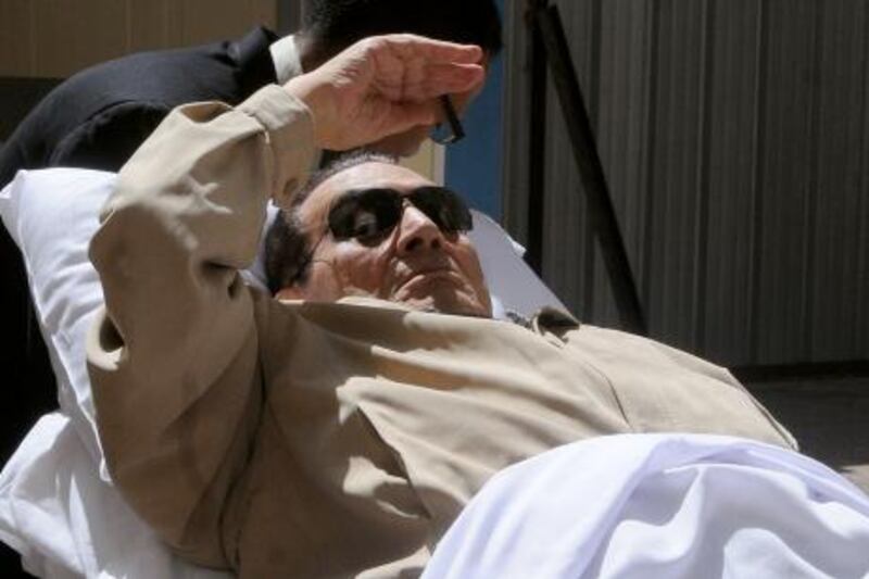 TOPSHOTS
Ousted Egyptian president Hosni Mubarak gestures as he is wheeled out of a courtroom following his verdict hearing in Cairo on June 2, 2012. A judge sentenced Mubarak to life in prison after convicting him of involvement in the murder of protesters during the uprising that ousted him last year. AFP PHOTO/STR
 *** Local Caption ***  666248-01-08.jpg