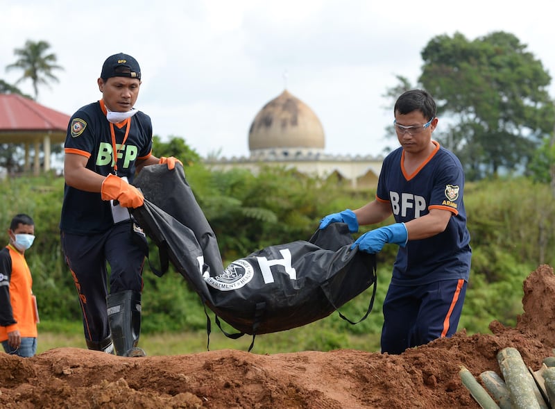 Rescuers carry a body bag containing the remains of a victim of Marawi siege during a mass burial at a public cemetery in Marawi on July 24, 2017, as the fighting between government troops and Muslim militants entered its second month.
The government is continuing to fight Islamist militants in the southern city of Marawi, a day after Congress voted to extend martial law over the southern Philippines until the end of the year.  / AFP PHOTO / TED ALJIBE