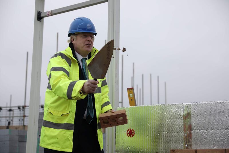 Britain's Prime Minister Boris Johnson lays a brick during a Conservative Party general election campaign visit to Barratt Homes's 'Willow Grove' residential housing development in Bedford, east England on November 21, 2019. Britain will go to the polls on December 12, 2019 to vote in a pre-Christmas general election. / AFP / POOL / Dan Kitwood
