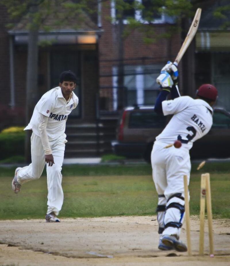 In this May 12, 2014 photo, John Adams High School batsman and bowler Derick Narine, left, bowls out Midwood High School batsman Hamza Khushnud, taking a wicket during a New York City high school match. Bebeto Matthews / AP