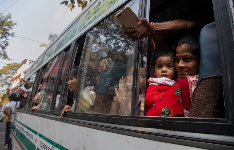 An Indian woman sits with her children inside a bus after being detained during a rally in Gauhati. AP Photo