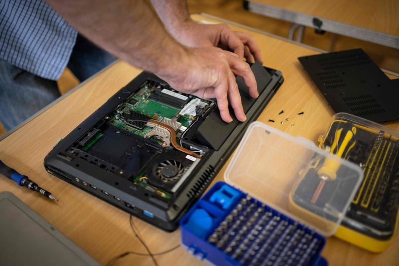 Damian Griffiths repairs a donated computer at Ewart Community Hall. AFP