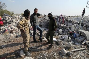 People look at a destroyed houses near the village of Barisha, in Idlib province, Syria after an operation by the US military which targeted ISIS leader Abu Bakr Al Baghdadi. AP