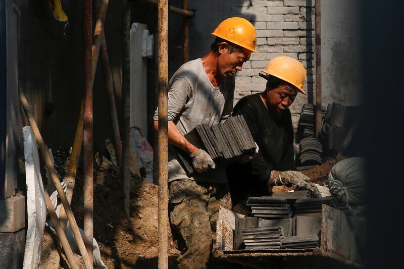 Men work at a construction site in a "hutong" alley in Beijing, China August 14, 2017. REUTERS/Thomas Peter