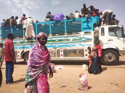 People board a lorry as they leave Khartoum. AP