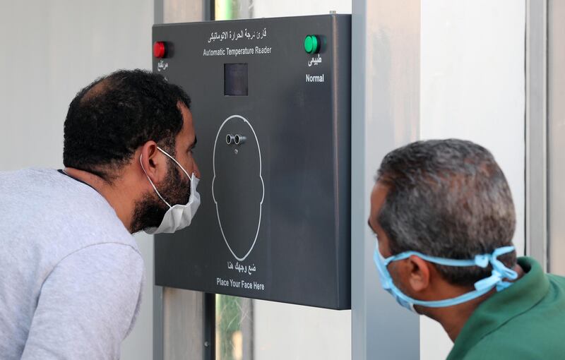 Egyptian people check their temperature at Cairo university after a repatriation flight from Kuwait in Giza, Egypt. EPA