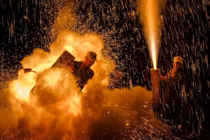 Men holding their handmade Tezutsu hanabi . AFP