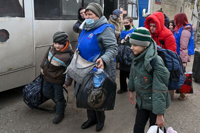 People prepare to board a bus to leave eastern Ukraine after Russian tanks and soldiers arrived in the Donetsk and Luhansk regions. (AP Photo)