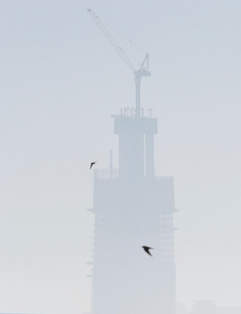 Birds fly in front of tower in a Sydney shrouded in haze as wildfires burn near the city on Tuesday, Nov. 19, 2019. AP