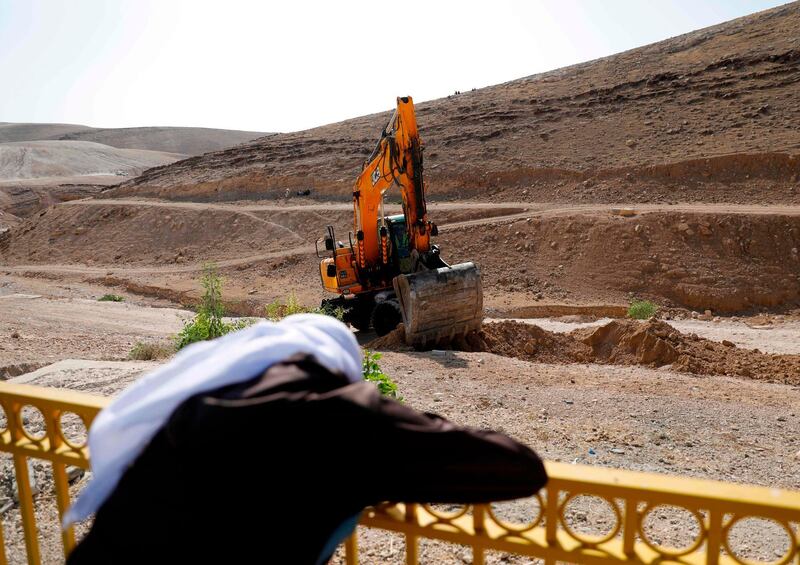 A bedouin man watches as an excavator digs in the Palestinian Bedouin village of Khan al-Ahmar, east of Jerusalem in the occupied West Bank on July 4, 2018. Khan al-Ahmar, which Israeli authorities say was illegally constructed and the supreme court in May rejected a final appeal against its demolition, is located near several Israeli settlements along a road leading to the Dead Sea.
Activists are concerned continued Israeli settlement construction in the area could effectively divide the northern and southern West Bank. / AFP / Ahmad GHARABLI
