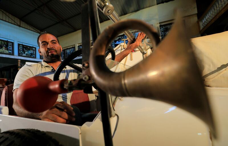 Sayed Sima sits on an Italian 1928 Fiat 501 automobile at his father's store. Reuters