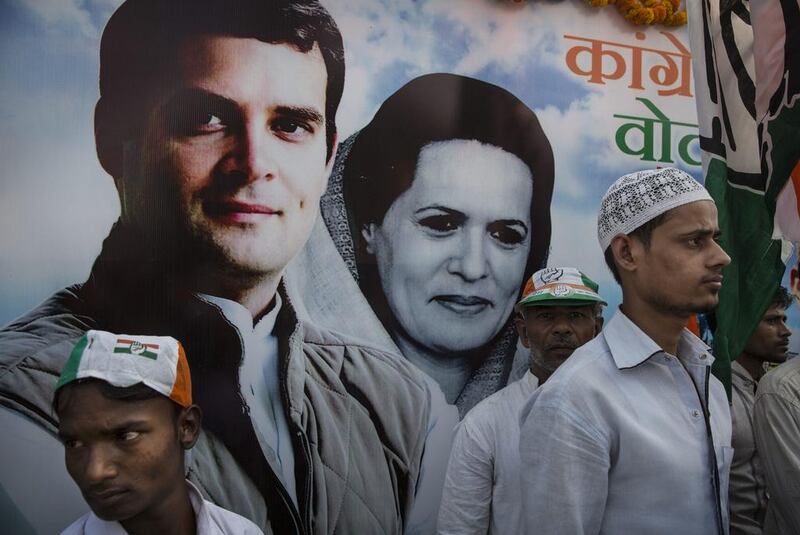 Congress party supporters stand in front of a poster that has president Sonia Gandhi and her son, Rahul Gandhi, on display. Getty Images