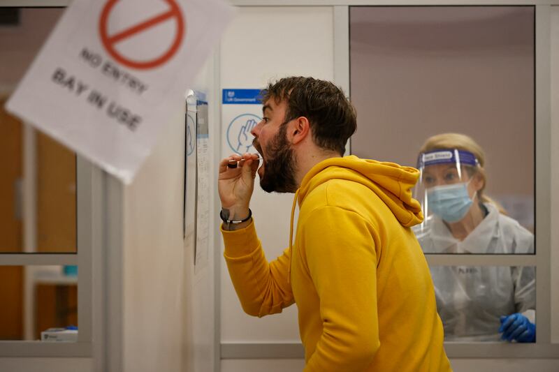 A man uses a swab to take a sample for a Covid test in London. PCR tests are expected soon to be scrapped for travellers and replaced with lateral flow tests. AFP