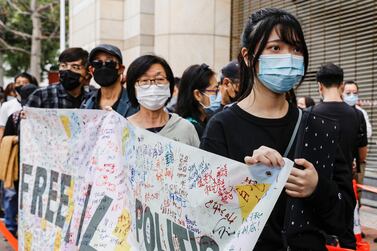 Supporters hold a banner to support pro-democracy activists as they queue up for a court hearing over the national security law outside West Kowloon Magistrates' Courts, in Hong Kong. Reuters