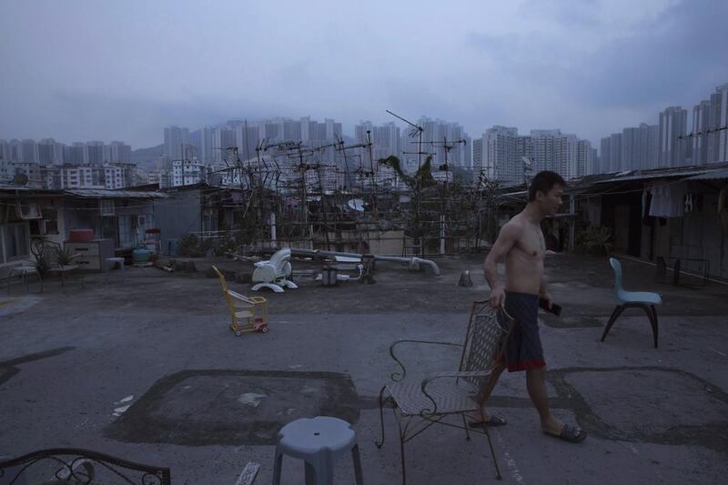 A resident walks outside his illegal rooftop hut, which is located next to a public housing estate. The US-based consultancy Demographia has ranked Hong Kong the world’s least affordable housing market for seven straight years.