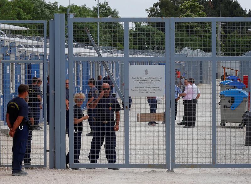 FILE PHOTO: Security guards stand by the gate of the transit zone where migrants are hosted in container camps and their asylum claims are processed, in Tompa, Hungary, June 14, 2017. REUTERS/Laszlo Balogh/File Photo