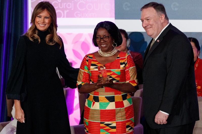 Dr Beauty Rita Nyampinga, of Zimbabwe, holds up her award as she is flanked by First Lady Melania Trump and Secretary of State Mike Pompeo.  AP