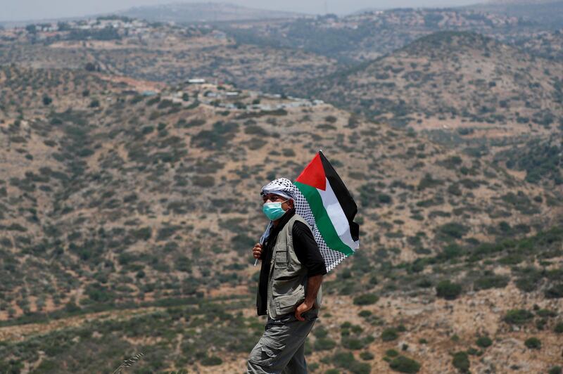 A demonstrator holding a Palestinian flag attends a protest against Jewish settlements, in the town of Biddy in the Israeli-occupied West Bank. Reuters