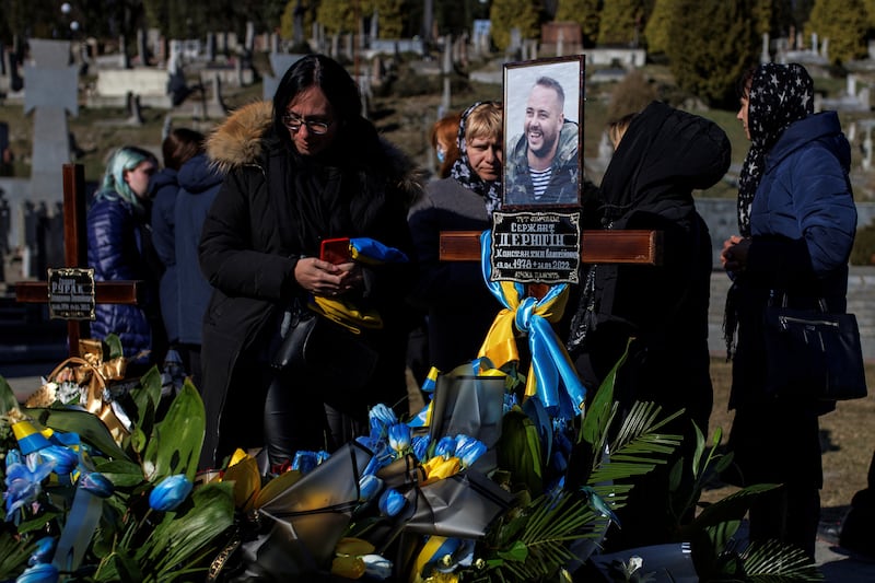 The widow of sergeant Kostiantyn Deriuhin stands at her husband's grave after his funeral at Lychakiv cemetery in Lviv, Ukraine. Reuters