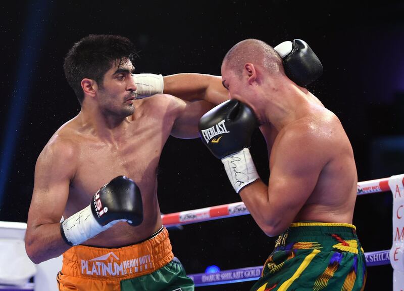 (FILES) In this file photo taken on August 5, 2017 Indian boxer and WBO Asia-Pacific Super Middleweight champion Vijender Singh (L) throws a punch at WBO Oriental Super Middleweight champion of China Zulpikar Maimaitiali during their double title bout at the National Sports Complex of India (NSCI) Dome in Mumbai. Indian boxing superstar Vijender Singh is keen to trade punches with Mexico's Canelo Alvarez at Madison Square Garden after signing a new deal with the legendary US promoter Bob Arum. The 33-year-old Singh, a bronze medallist at the 2008 Beijing Olympics, has an unbeaten 10-0 record since he turned pro in 2015, but failed to get a single fight this year. / AFP / PUNIT PARANJPE                      
