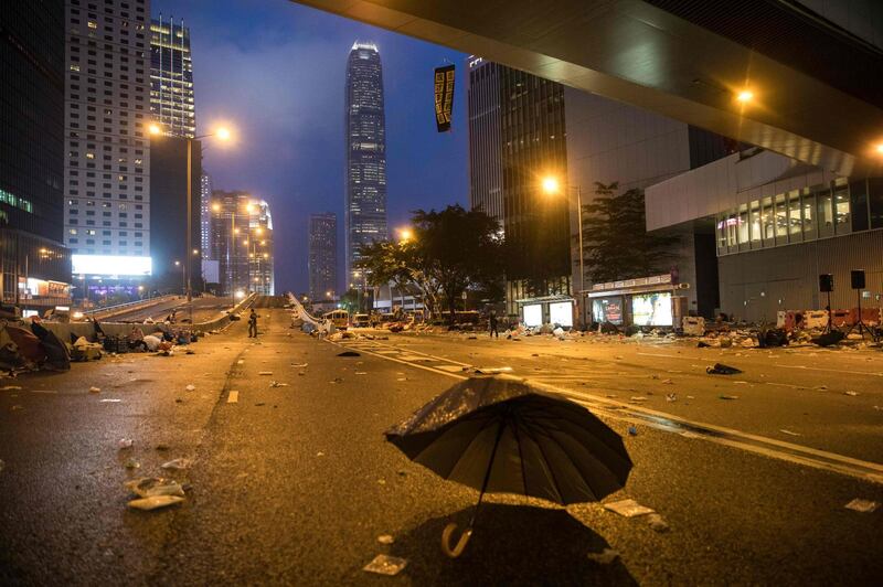 A broke umbrella lies on a road after protesters were cleared from the area during a rally against a extradition law proposal outside the government headquarters in Hong Kong..  AFP