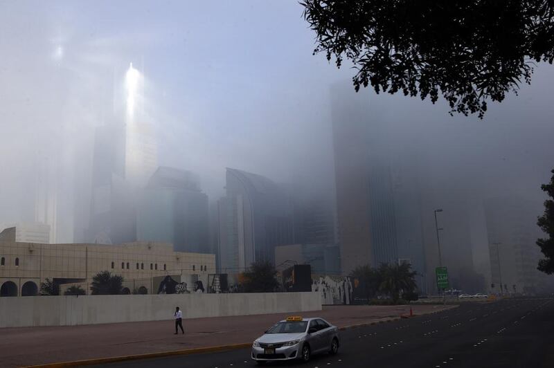 Sun rays pass through the thick fog on Hamdan street in Abu Dhabi. Ravindranath K / The National