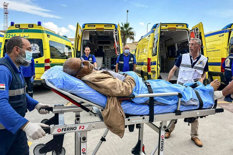 An injured Palestinian man is moved past Egyptian health ministry ambulances on the Egyptian side of the Rafah border crossing with the Gaza Strip on Tuesday. AFP