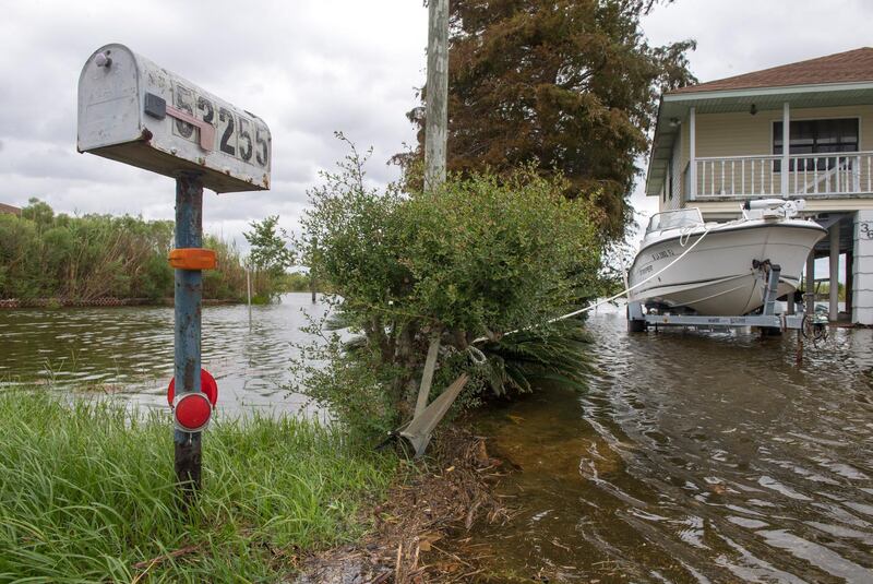 A boat is anchored to a small shrub near this mailbox in a front yard just south of Slidell,  Louisiana, but high water still affected the area. AP