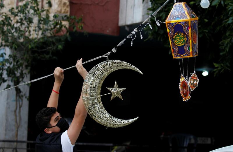 A man puts Ramadan decorations on a street ahead of the Muslim holy month of Ramadan, during a countrywide lockdown over the coronavirus disease (COVID-19) in Beirut, Lebanon April 19, 2020. Picture taken April 19, 2020. REUTERS/Mohamed Azakir