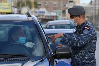 A police officer wearing a face mask talks with a driver at a checkpoint in Sidon, Lebanon. Reuters