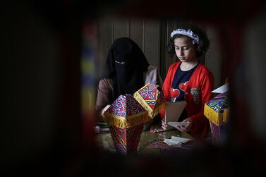TOPSHOT - Members of the Palestinian al-Yaqoubi family gather around a table during the novel coronavirus lockdown, to make lanterns to sell ahead of the Muslim holy month of Ramadan, in Khan Yunis, in the southern Gaza Strip on April 15, 2020. / AFP / SAID KHATIB