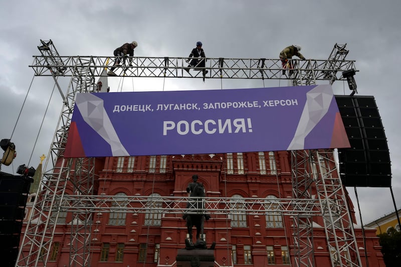 Workers fix a banner reading 'Donetsk, Luhansk, Zaporizhzhia, Kherson - Russia!' to the State Historical Museum near Red Square in Moscow. AFP