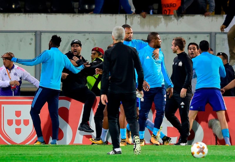 TOPSHOT - Marseille's defender Patrice Evra (C) leaves the pitch after an incident with Marseille supporters before the start of the UEFA Europa League group I football match Vitoria SC vs Marseille at the D. Afonso Henriques stadium in Guimaraes on November 2, 2017. / AFP PHOTO / MIGUEL RIOPA