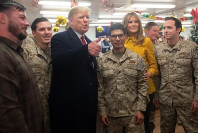 US President Donald Trump and First Lady Melania Trump greet members of the US military during an unannounced trip to Al Asad Air Base in Iraq on December 26, 2018. - President Donald Trump arrived in Iraq on his first visit to US troops deployed in a war zone since his election two years ago (Photo by SAUL LOEB / AFP)
