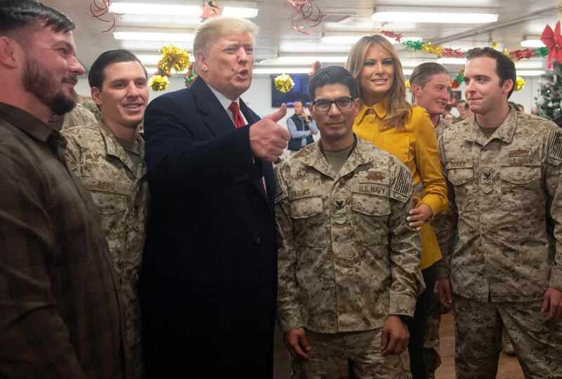 US President Donald Trump and First Lady Melania Trump greet members of the US military during an unannounced trip to Al Asad Air Base in Iraq on December 26, 2018. - President Donald Trump arrived in Iraq on his first visit to US troops deployed in a war zone since his election two years ago (Photo by SAUL LOEB / AFP)