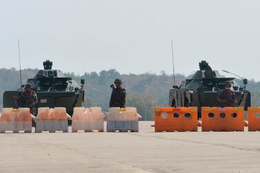 Soldiers stand guard on a blockaded road to Myanmar's parliament in Naypyidaw on February 1, 2021, after the military detained the country's de facto leader Aung San Suu Kyi and the country's president in a coup. AFP