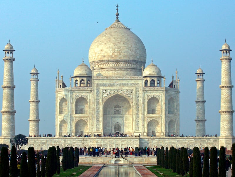 Tourists stand in front of the historic Taj Mahal in the northern Indian city of Agra January 17, 2009. The Taj Mahal was built by Emperor Shah Jahan in memory of his wife and is one of the world's most famous monuments. REUTERS/Vijay Mathur (INDIA) - GM1E51I0E5W01